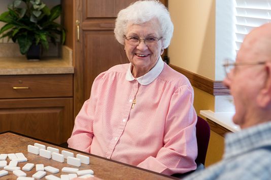 patients laughing together playing dominoes