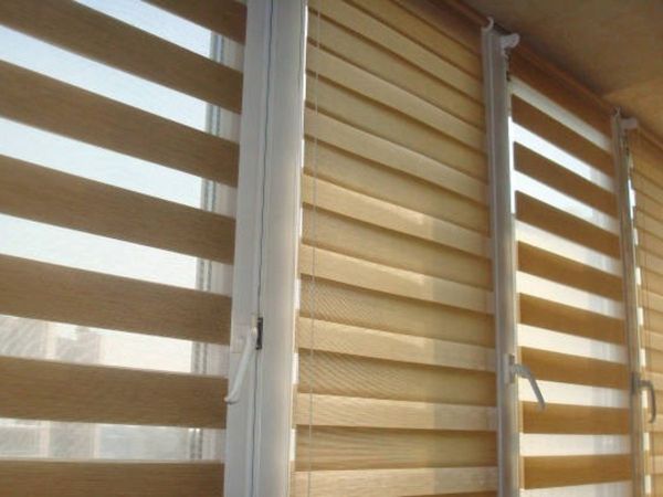 a close-up of striped dual shades in a light tan color, showing the alternating opaque and sheer layers. a close-up of striped dual shades in a light tan color, showing the alternating opaque and sheer layers.