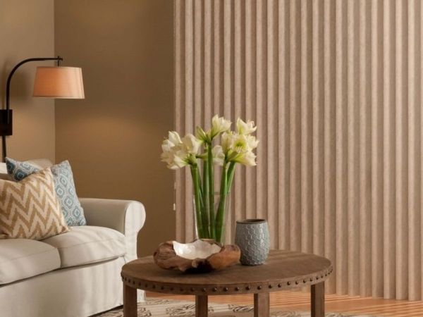a cozy living room with a sofa and a large glass door covered by neutral-colored vertical blinds. a cozy living room with a sofa and a large glass door covered by neutral-colored vertical blinds.