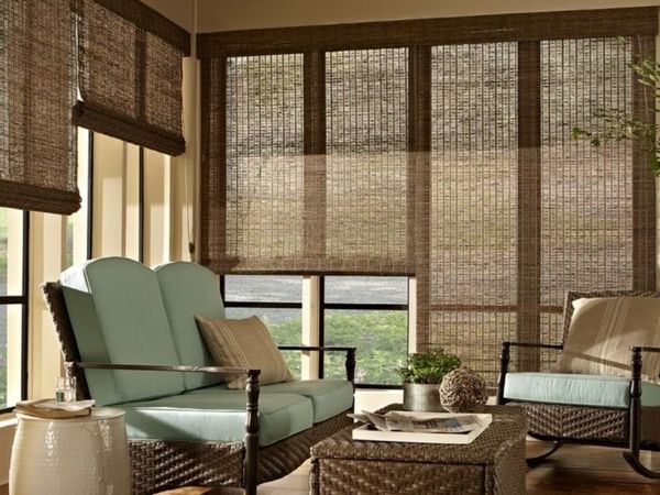 a sunroom with large windows featuring natural woven shades and comfortable wicker seating. a sunroom with large windows featuring natural woven shades and comfortable wicker seating.