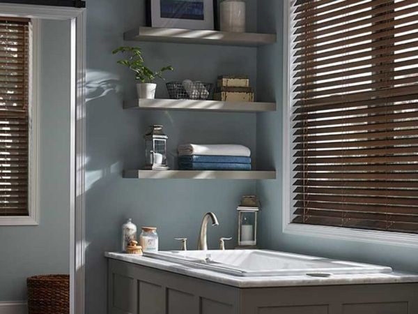  bathroom with a modern sink and shelves, featuring dark wood blinds on the windows.