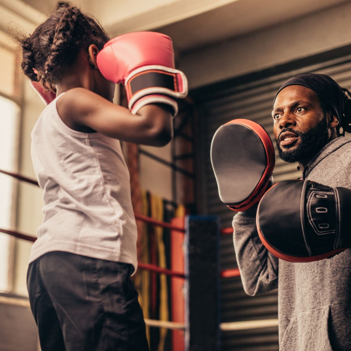 kid and father using boxing gloves 