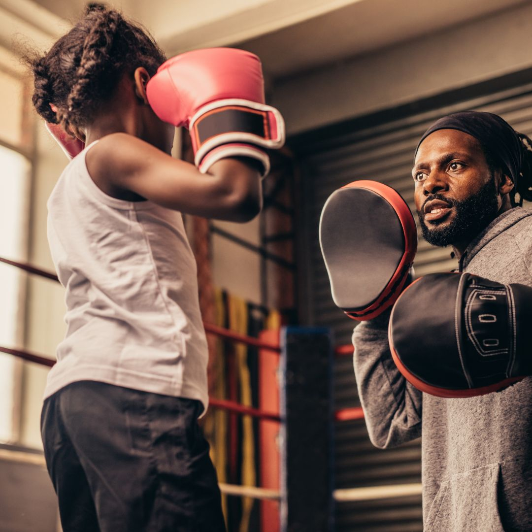 kid and father using boxing gloves 