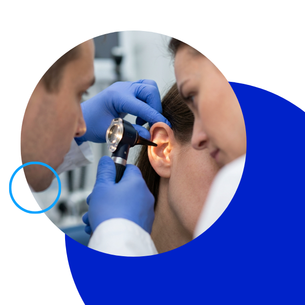 Close up of a specialist performing an ear examination with a handheld tool.