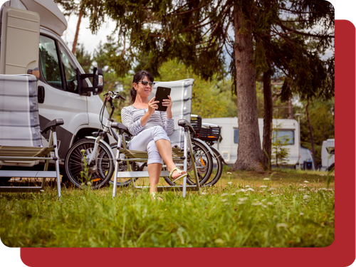 A woman relaxing next to her RV