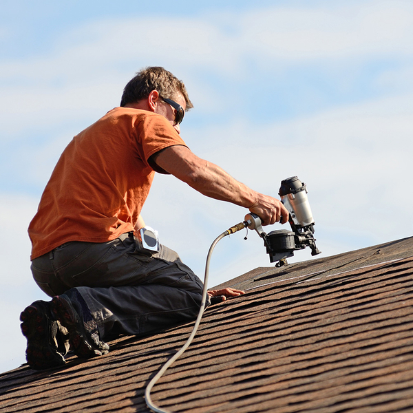 Roofer installing new shingles on a roof