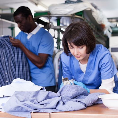 laundromat workers spot cleaning clothes