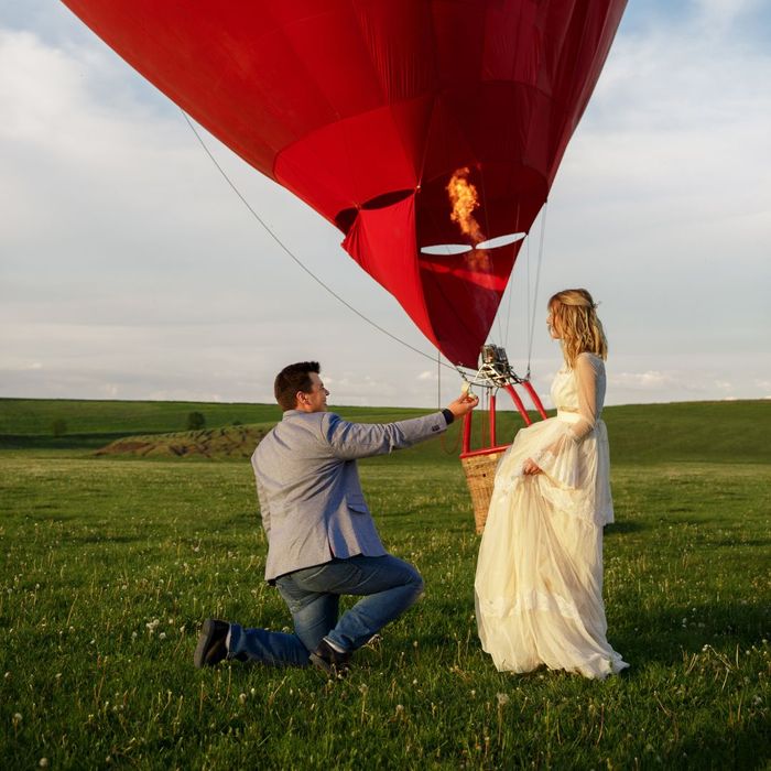 man proposing in front of an air balloon