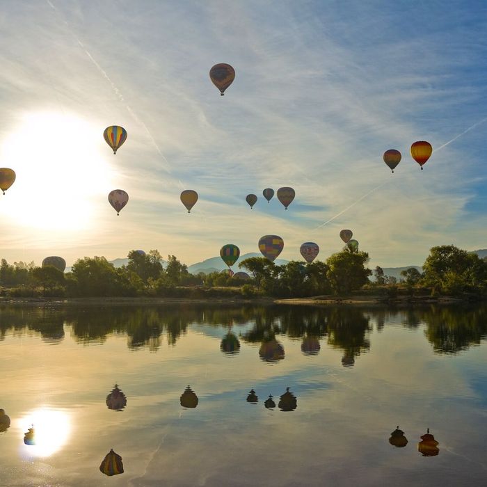 Hot air balloons flying over a lake