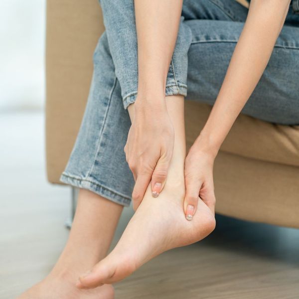 woman massaging wound on ankle