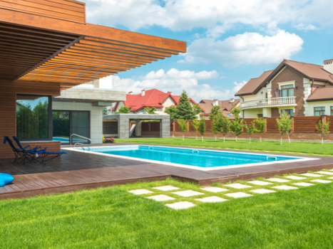 A modern home with pavers in the yard and a nice swimming pool