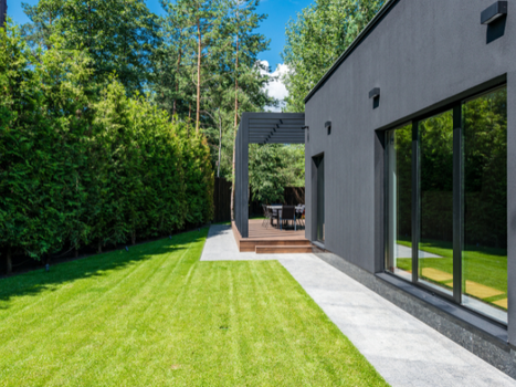 A paved walkway to a nice deck in the back of a home