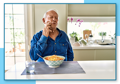 Man eating food but having tooth pain