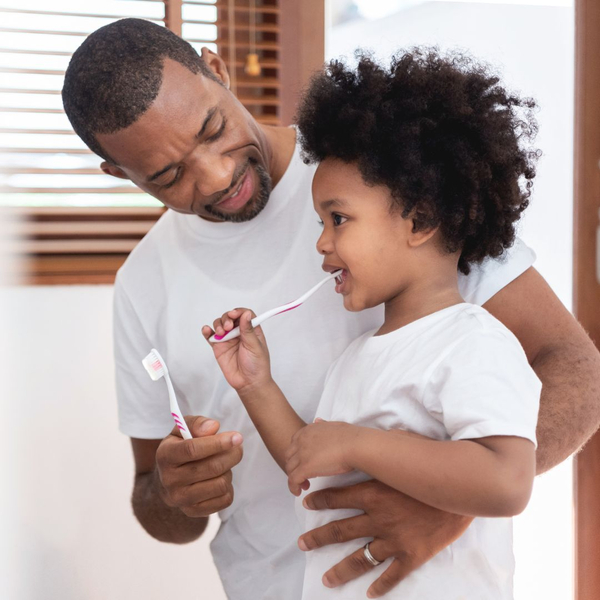 father and son brushing teeth