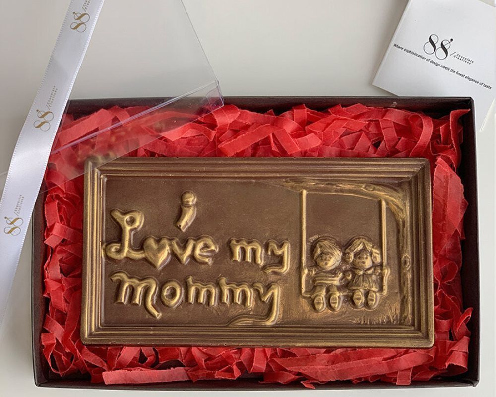 a chocolate bar with the words "I love my mommy" and two people swinging together