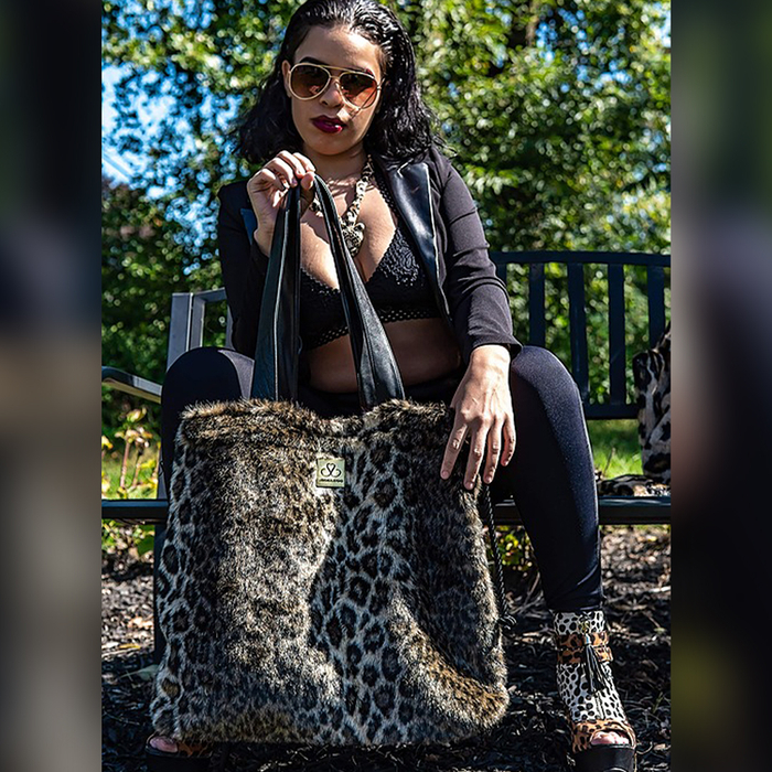 Woman holding the Shoelugg in a cheetah print design.