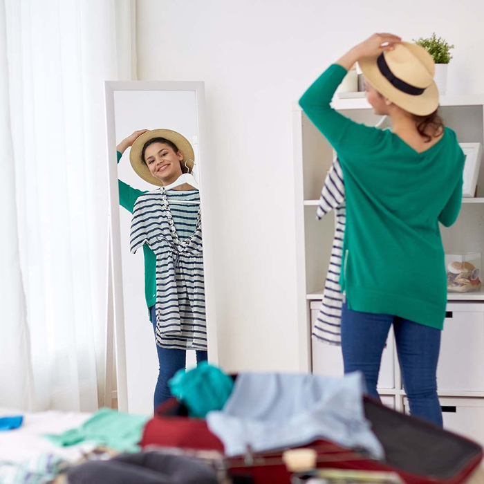 a woman planning out an outfit in the mirror