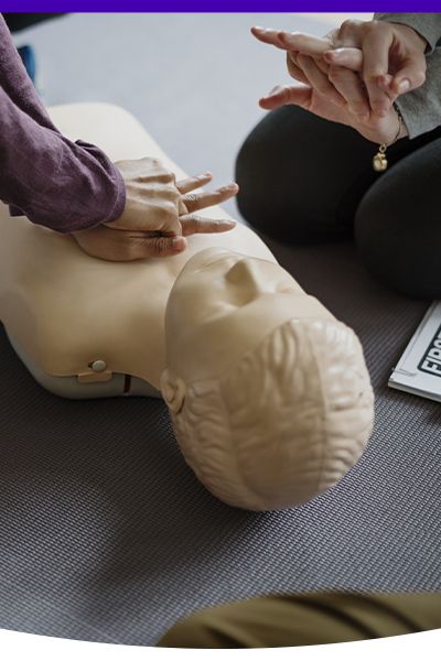 a person practicing CPR on a CPR training doll