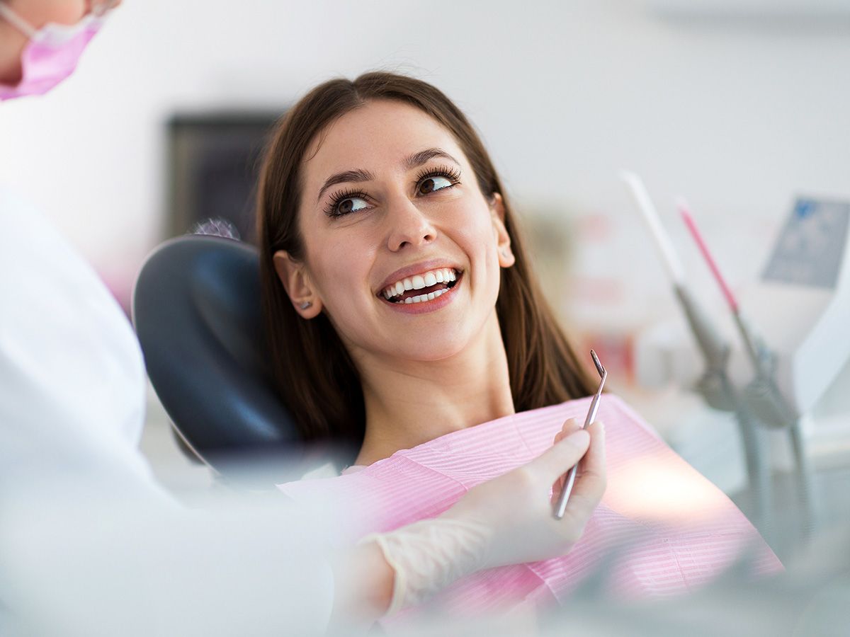 photo of woman smiling while sitting in dentist chair