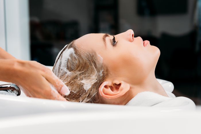 side-view-of-hairdresser-washing-hair-for-customer-PJXVZWE.jpg