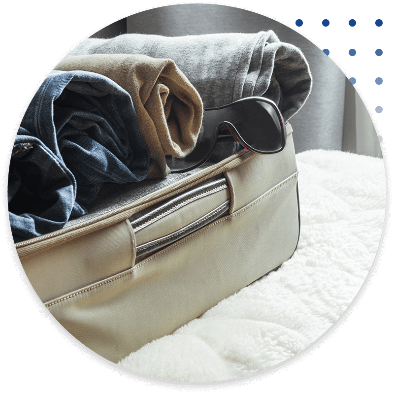 Open door and open suitcase with clothes.