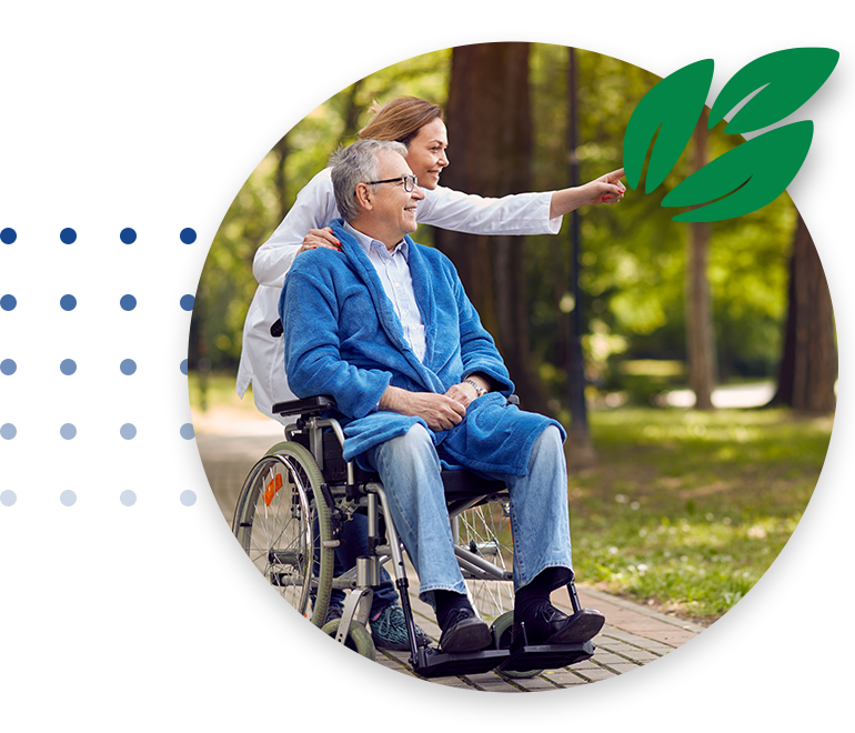 Nurse showing something to elderly men on wheelchair in the park