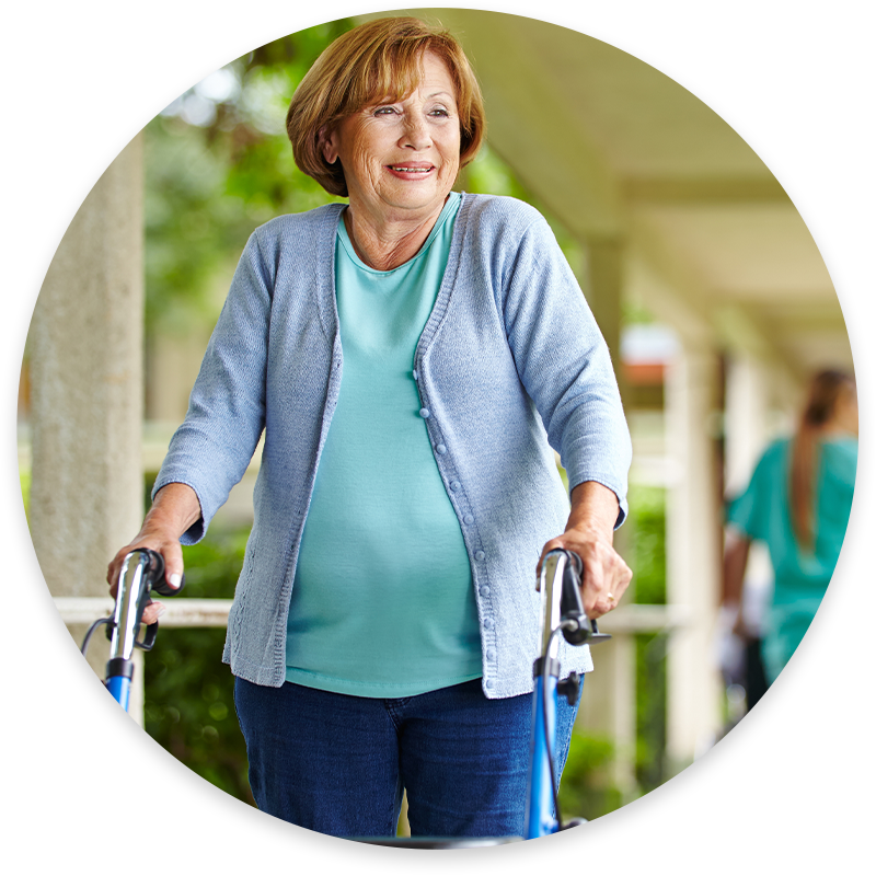 happy senior woman with walker on a stroll through nursing home campus