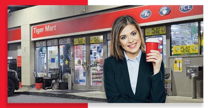 woman with red coffee cup in front of gas station