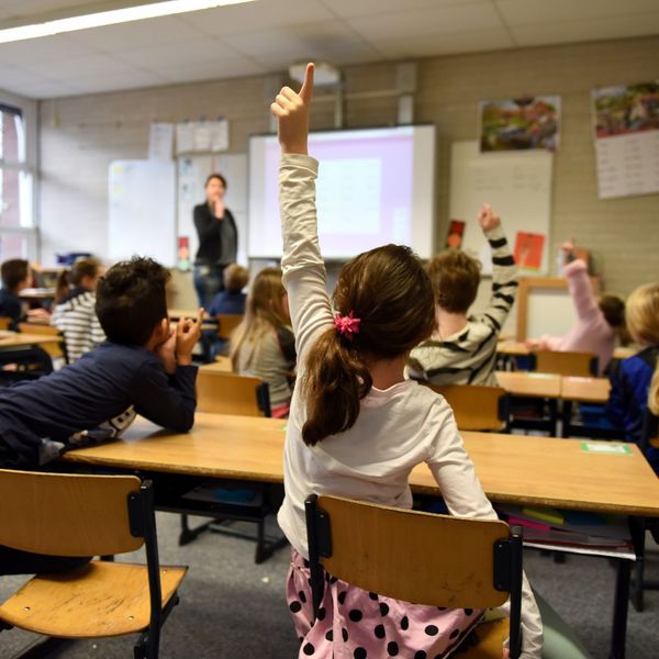 student raising hand in classroom, padded floor
