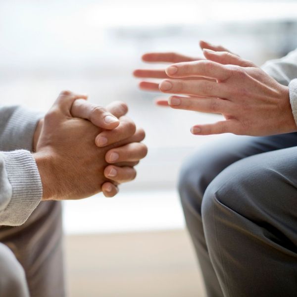 close up of men's hands, one clasped, and one set open