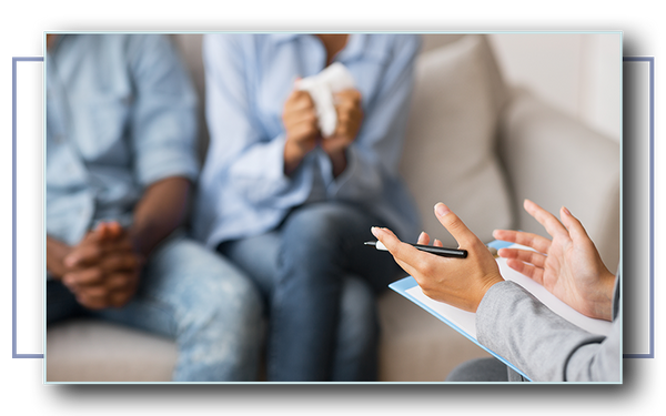  A Black couple sitting across from a couples counselor.