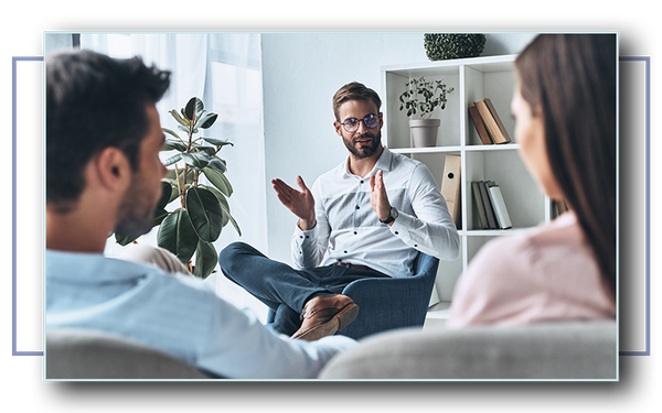 Young couple listening to psychologist while sitting on the therapy session