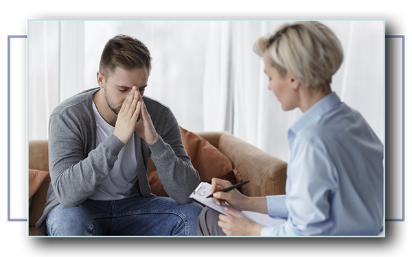 Man sitting on a couch talking with a counselor.