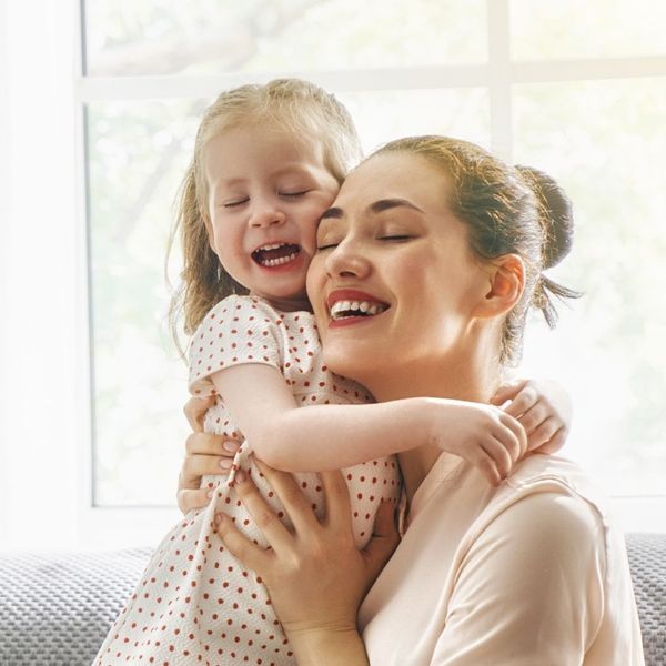 happy mother playing with young daughter