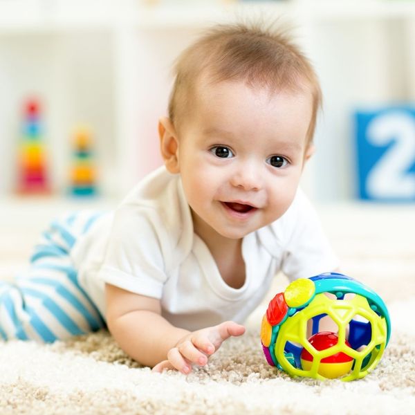 smiling baby playing with toy in daycare smiling baby playing with toy in daycare