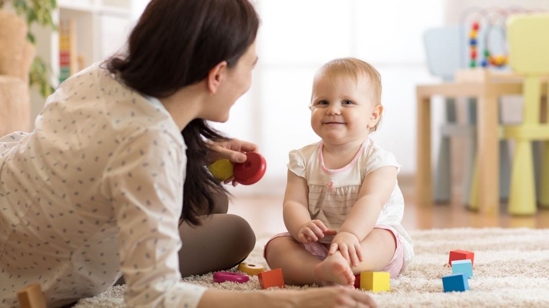 daycare worker playing with blocks with baby daycare worker playing with blocks with baby