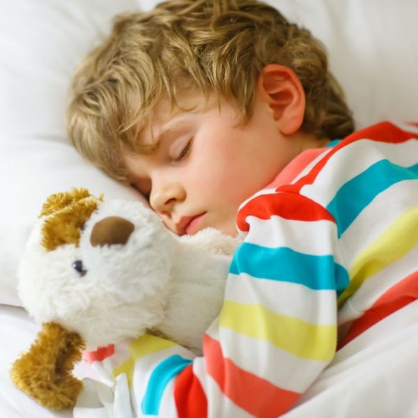sleeping child holding a stuffed animal