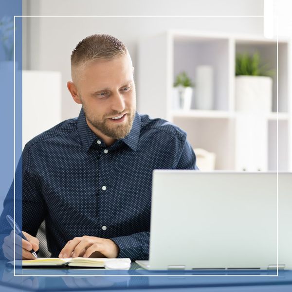 a man taking notes from his computer