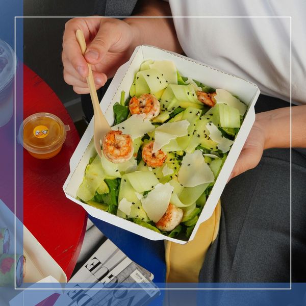 Person eating a healthy meal with shrimp and greens