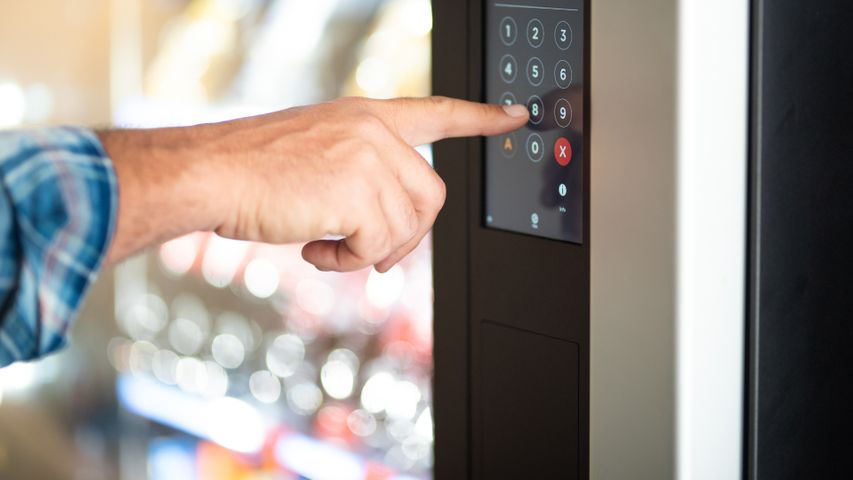 Hand pressing buttons on a vending machine