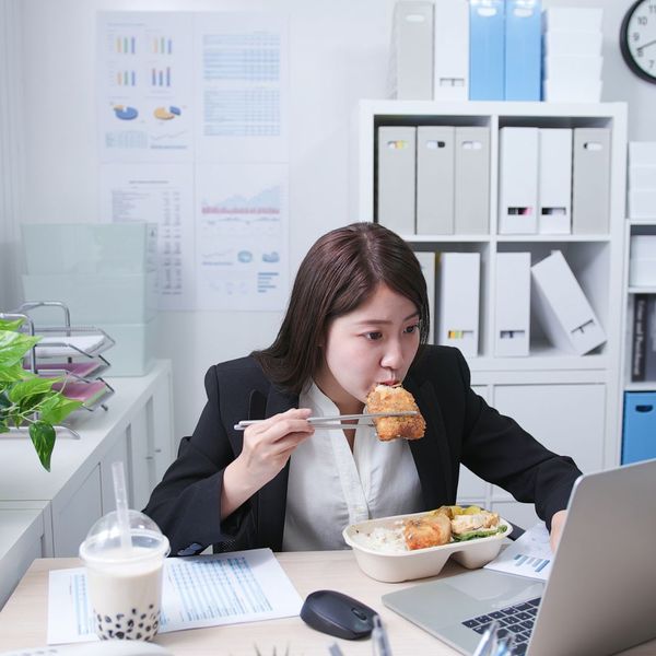 a woman eating a full meal at her desk