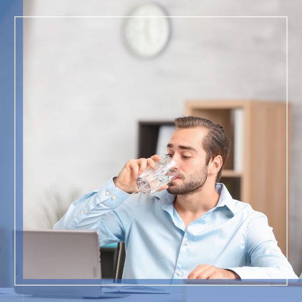 a man drinking water at his desk