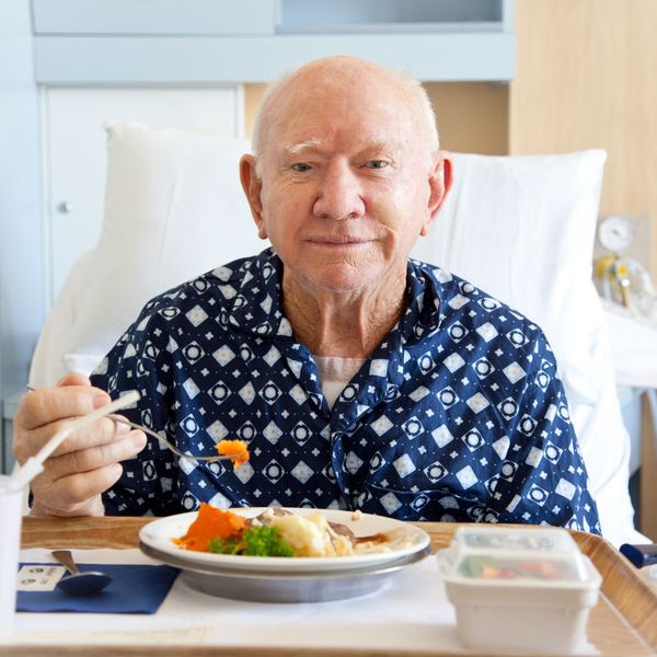 a man smiling with a plate of veggies