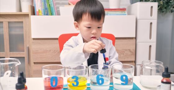 child using a pipette with beakers
