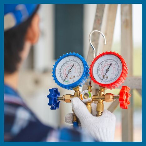 An HVAC technician holding a gauge for HVAC equipment