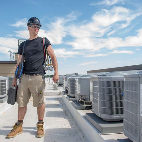 HVAC tech on commercial roof 