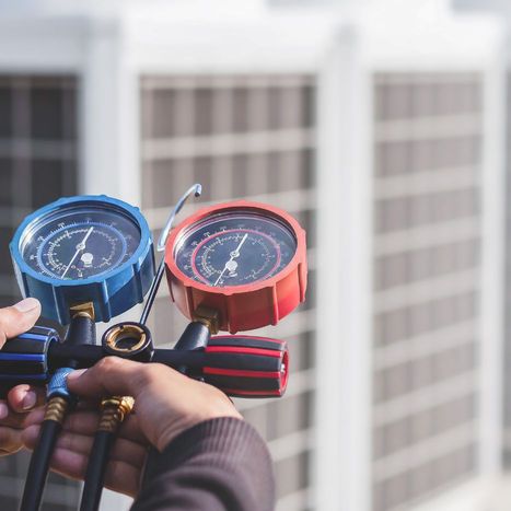 HVAC technician using a gauge