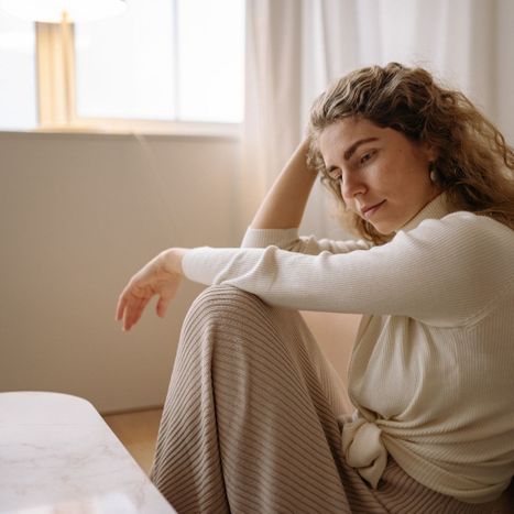woman too hot, sitting on floor with head resting on  hand
