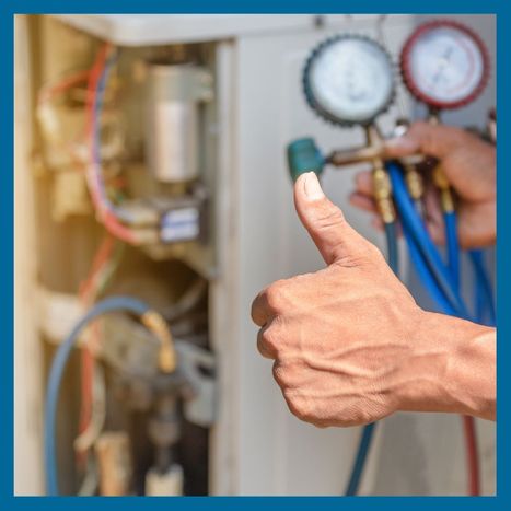 HVAC tech holding a gauge and giving a thumbs-up