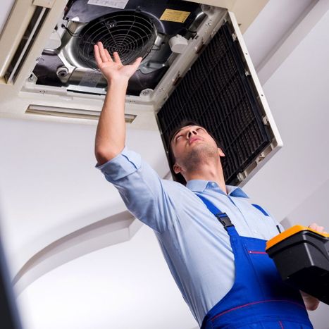 reaching up to repair AC vent